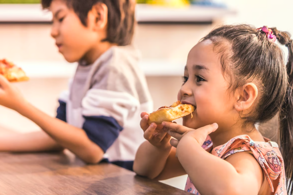 Food pantry: Kids Eat Free summer feeding program at CCA. Kids eating lunch.